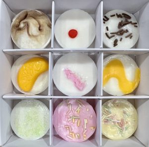 A beautiful white square gift box filled with 9 cupcake scented soy wax melts.